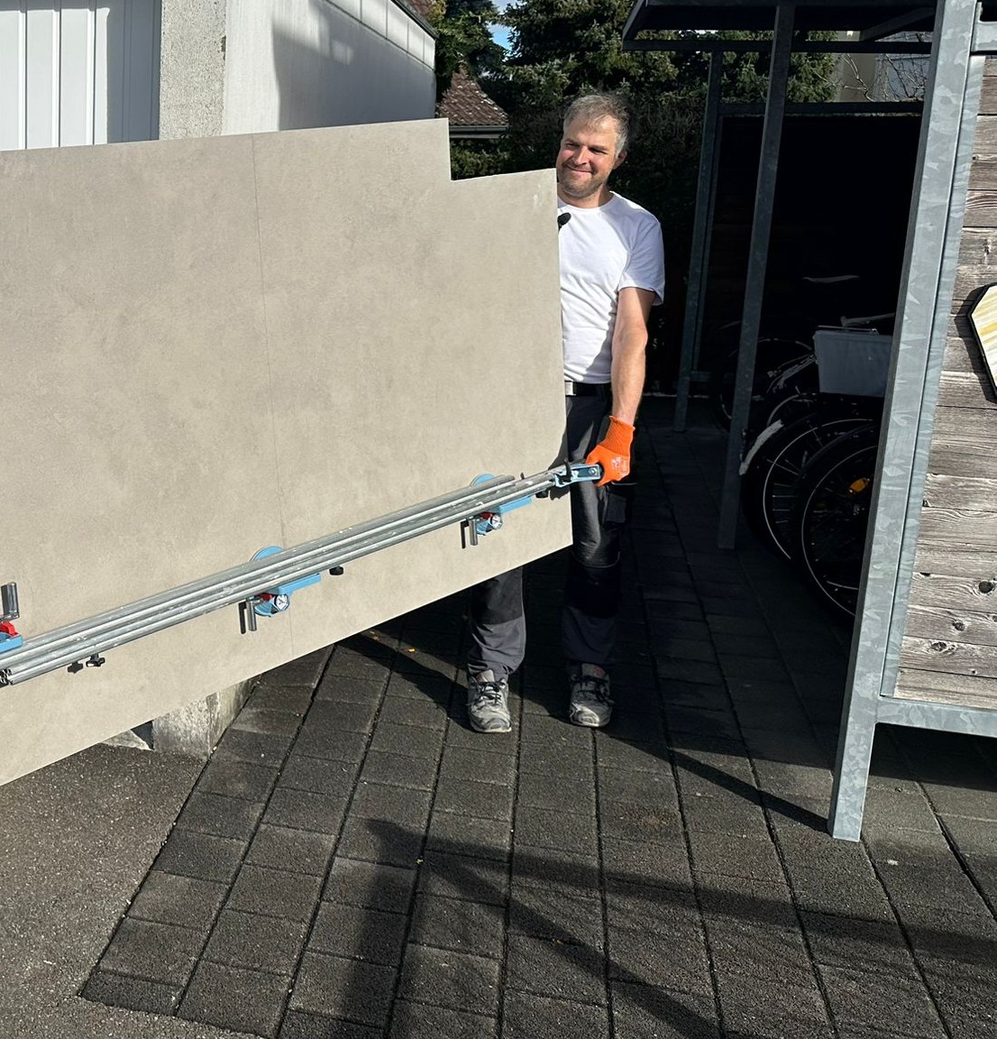 Thomas Töngi, eidg. dipl. Plattenlegermeister, trägt eine XXL-Feinsteinzeugplatte am Transportgerät